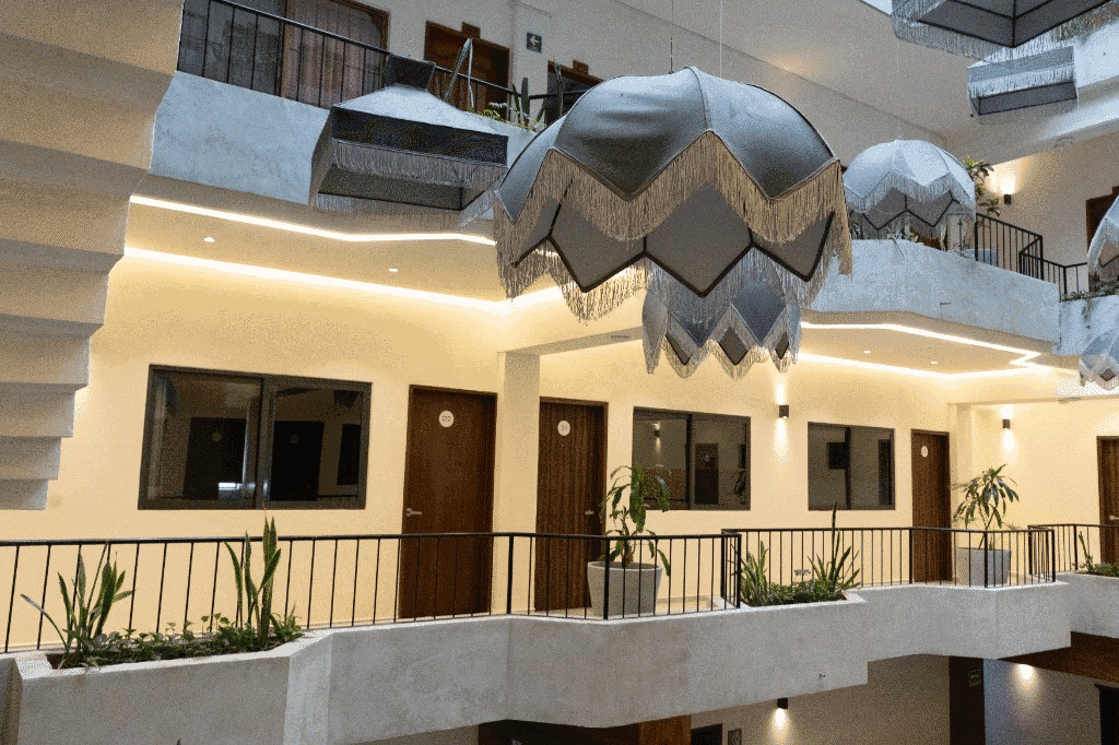 Pasillos y balcones del hotel con iluminación cálida y vegetación
